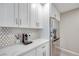 Stylish kitchen features white cabinets, marble countertops, stainless steel refrigerator, and tile backsplash at 4211 Saxton Green Ave, Las Vegas, NV 89141