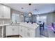 Kitchen view to dining area showcasing the island seating, quartz countertops, and stainless steel appliances at 4211 Saxton Green Ave, Las Vegas, NV 89141