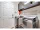Well-lit laundry room with modern washer and dryer, cabinets, and a convenient side entry door at 4211 Saxton Green Ave, Las Vegas, NV 89141
