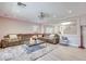 Inviting living room with a comfortable sectional sofa, a large mirror, and wood flooring at 4211 Saxton Green Ave, Las Vegas, NV 89141