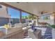 Outdoor patio with ample seating for entertaining featuring couches and a dining table at 4211 Saxton Green Ave, Las Vegas, NV 89141