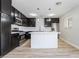 Modern kitchen featuring an island, stainless steel appliances, subway tile backsplash, and dark cabinets at 4857 Fairfax Ave, Las Vegas, NV 89120