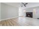Bright living room featuring light wood floors, ceiling fan and a black brick fireplace at 4857 Fairfax Ave, Las Vegas, NV 89120