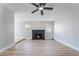 Bright living room with ceiling fan, light wood flooring, fireplace and large windows at 4857 Fairfax Ave, Las Vegas, NV 89120