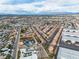 An aerial view of a residential neighborhood and commercial buildings with the city skyline at 5050 Secret Rock St, Las Vegas, NV 89122