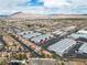 Stunning aerial view of a neighborhood highlighting warehouses, homes, and scenic mountain backdrop at 5050 Secret Rock St, Las Vegas, NV 89122