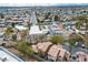 An aerial view showcases a neighborhood with a community pool and a clear view of city in distance at 5050 Secret Rock St, Las Vegas, NV 89122