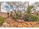 Landscaped backyard features a rock waterfall, pond, stone patio, trees, and desert plants at 5050 Secret Rock St, Las Vegas, NV 89122