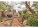 Backyard with a stone pathway, a wooden fence, and landscaping at 5050 Secret Rock St, Las Vegas, NV 89122