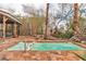Backyard oasis featuring a tiled pool with an attached spa, mature palms, and covered seating area at 5050 Secret Rock St, Las Vegas, NV 89122