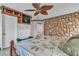 Bedroom with a stone wall and a bed, plus a decorative fan and wallpaper at 5050 Secret Rock St, Las Vegas, NV 89122