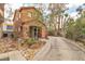 Side view of a tan two-story home with desert landscaping and a long, paved driveway at 5050 Secret Rock St, Las Vegas, NV 89122