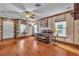 Well-lit living room with hardwood floors, a ceiling fan, and a stone accent wall at 5050 Secret Rock St, Las Vegas, NV 89122