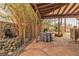 Inviting outdoor patio featuring a charming stone waterfall, covered dining area, and lush greenery at 5050 Secret Rock St, Las Vegas, NV 89122