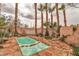 Backyard pool area with stone tile, mature palm trees, and tranquil water feature at 5050 Secret Rock St, Las Vegas, NV 89122