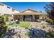 This backyard is perfect for outdoor living, with a hot tub, covered patio, seating, and rock garden feature at 5317 Clover Blossom Ct, North Las Vegas, NV 89031