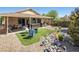 This backyard has a hot tub, covered patio, seating area, and unique rock landscaping design creating a serene outdoor space at 5317 Clover Blossom Ct, North Las Vegas, NV 89031