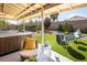 The backyard oasis has a modern hot tub, covered patio with a ceiling fan, and artificial turf for low maintenance at 5317 Clover Blossom Ct, North Las Vegas, NV 89031