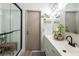 Bright bathroom featuring a glass shower, double sinks, and decorative shelves at 5317 Clover Blossom Ct, North Las Vegas, NV 89031