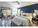 Comfortable bedroom with a blue accent wall, bench, and sliding doors to an outdoor patio at 5317 Clover Blossom Ct, North Las Vegas, NV 89031