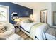 This bedroom boasts a blue accent wall, seating, and plenty of natural light at 5317 Clover Blossom Ct, North Las Vegas, NV 89031