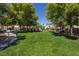 The lush green community park features mature trees, walking paths, and a fenced playground area for ' entertainment at 5317 Clover Blossom Ct, North Las Vegas, NV 89031