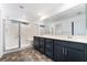 Bathroom featuring a double vanity, large mirror, and glass-enclosed shower with bench at 5745 Becklow Gardens Ave, Las Vegas, NV 89141
