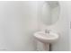 Clean powder room featuring a pedestal sink and a round mirror, ideal for guests and convenience at 5745 Becklow Gardens Ave, Las Vegas, NV 89141
