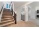 Carpeted staircase with dark wood railings leading to a spacious upper level with bright, airy spaces at 5745 Becklow Gardens Ave, Las Vegas, NV 89141