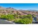Community aerial showcasing green common area, homes with terracotta roofs, and mountain views at 605 Bachelor Button St, Las Vegas, NV 89138