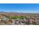 Expansive aerial view of a community with terracotta rooftops and mountain backdrop under a clear blue sky at 605 Bachelor Button St, Las Vegas, NV 89138