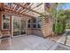 Back patio area with concrete flooring, overhead trellis and sliding glass doors at 605 Bachelor Button St, Las Vegas, NV 89138