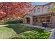 Serene backyard featuring a covered patio, lush green lawn, mature trees, and privacy fence at 605 Bachelor Button St, Las Vegas, NV 89138