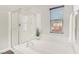 Bright bathroom featuring a soaking tub, a glass-enclosed shower, and a window for natural light at 605 Bachelor Button St, Las Vegas, NV 89138