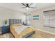Bright bedroom featuring a queen bed, ceiling fan, and a side table with lamps at 605 Bachelor Button St, Las Vegas, NV 89138