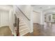 Inviting hallway featuring wood and iron stair rail and dark flooring, seamlessly connecting different living spaces at 605 Bachelor Button St, Las Vegas, NV 89138