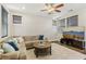 A spacious living room with a comfortable sectional, large windows, and an entertainment center at 605 Bachelor Button St, Las Vegas, NV 89138