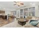 Open concept living area with large windows, tile flooring, a comfortable sectional, and adjacent kitchen area at 605 Bachelor Button St, Las Vegas, NV 89138