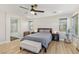 Spacious main bedroom with a comfortable bed, warm wood floors and an en-suite bathroom with tub at 605 Bachelor Button St, Las Vegas, NV 89138