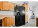 Bright kitchen features wood cabinets and modern black refrigerator with water and ice dispenser at 6901 Squaw Mountain Dr # 201, Las Vegas, NV 89130