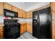 A kitchen with light wood cabinets and black appliances showcasing practicality and style at 6901 Squaw Mountain Dr # 201, Las Vegas, NV 89130