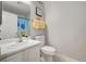 Cheerful bathroom features a white vanity, toilet, and mirror; fun decor at 713 Salt Flats Cir, Henderson, NV 89011