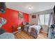 Bedroom features red accent wall, wood-look floors, and a desk area near the window at 713 Salt Flats Cir, Henderson, NV 89011
