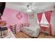 Bright pink bedroom features wood-look floors, a desk area and cheerful decor at 713 Salt Flats Cir, Henderson, NV 89011