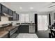 Modern kitchen with stainless steel appliances, dark cabinetry, and sliding glass doors to the outside at 713 Salt Flats Cir, Henderson, NV 89011