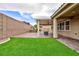 Lush backyard with artificial grass and a covered patio, ideal for entertaining guests at 7525 Campbell Ranch Ave, Las Vegas, NV 89179