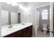 Bright bathroom with a large mirror, a cherry-wood vanity, and an adjacent toilet and shower area at 7525 Campbell Ranch Ave, Las Vegas, NV 89179