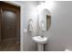 Bathroom featuring a pedestal sink, oval mirror, neutral wall paint, and tile flooring that extends into the hallway at 7525 Campbell Ranch Ave, Las Vegas, NV 89179