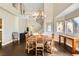 Open-concept dining area with a grand chandelier, hardwood floors, and views to the staircase and front door at 7636 Sudan Ct, Las Vegas, NV 89149