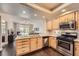 Functional kitchen with wooden cabinets, stainless steel appliances, and an open view to the living area at 7636 Sudan Ct, Las Vegas, NV 89149
